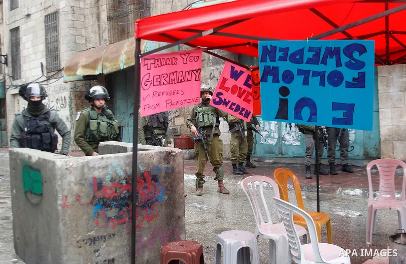Israeli security forces stand guard during a protest demanding to end the occupation and against settlement in the West Bank city of Hebron, on Feb. 08, 2016. Photo by Wisam Hashlamoun