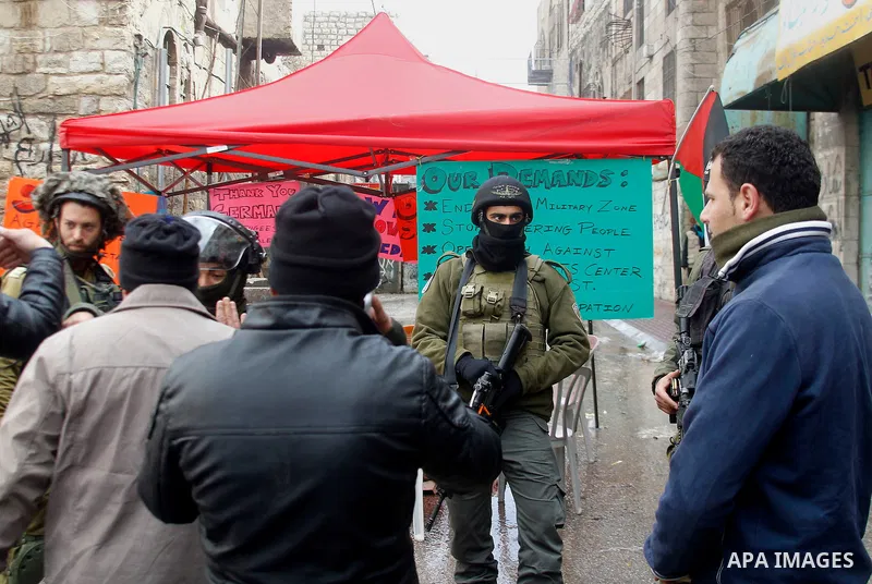 Palestinians argue with Israeli security forces during a protest demanding to end the occupation and against settlement in the West Bank city of Hebron, on Feb. 08, 2016. Photo by Wisam Hashlamoun