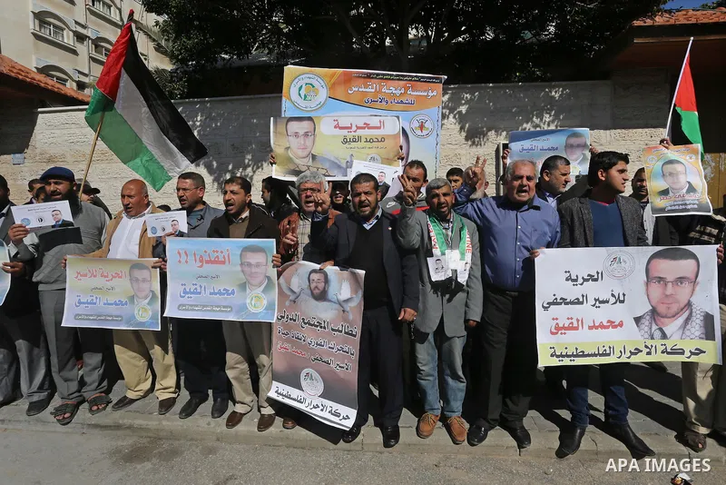Palestinians hold posters during a demonstration in support of hunger striking Palestinian journalist Mohammed al-Qiq, in front of Red cross office in Gaza city on February 9, 2016. The 33-year-old television reporter wi...