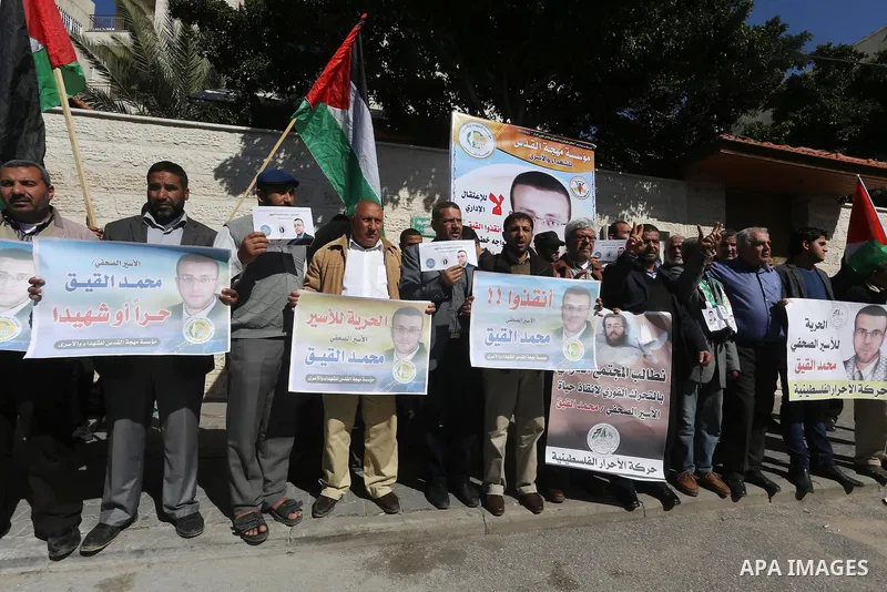 Palestinians hold posters during a demonstration in support of hunger striking Palestinian journalist Mohammed al-Qiq, in front of Red cross office in Gaza city on February 9, 2016. The 33-year-old television reporter wi...