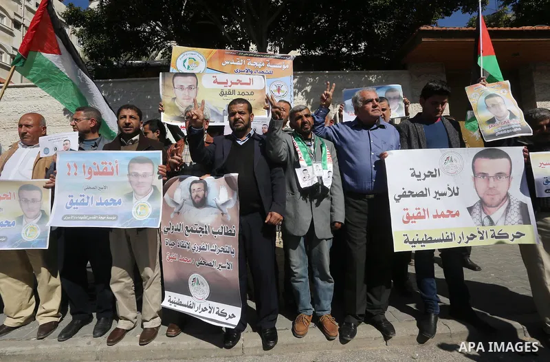 Palestinians hold posters during a demonstration in support of hunger striking Palestinian journalist Mohammed al-Qiq, in front of Red cross office in Gaza city on February 9, 2016. The 33-year-old television reporter wi...