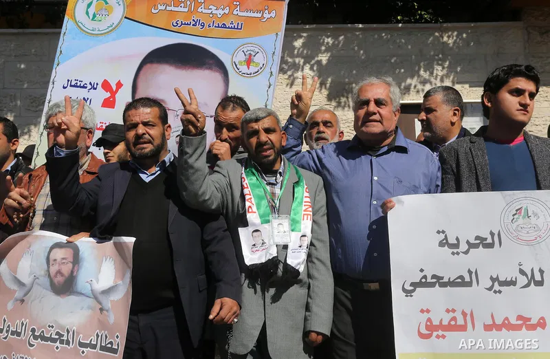 Palestinians hold posters during a demonstration in support of hunger striking Palestinian journalist Mohammed al-Qiq, in front of Red cross office in Gaza city on February 9, 2016. The 33-year-old television reporter wi...