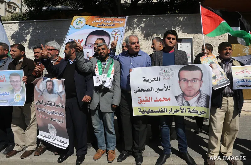 Palestinians hold posters during a demonstration in support of hunger striking Palestinian journalist Mohammed al-Qiq, in front of Red cross office in Gaza city on February 9, 2016. The 33-year-old television reporter wi...