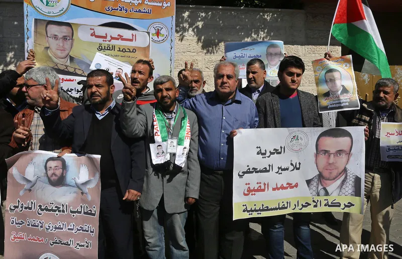 Palestinians hold posters during a demonstration in support of hunger striking Palestinian journalist Mohammed al-Qiq, in front of Red cross office in Gaza city on February 9, 2016. The 33-year-old television reporter wi...