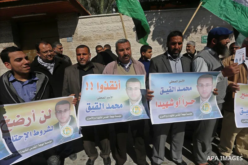 Palestinians hold posters during a demonstration in support of hunger striking Palestinian journalist Mohammed al-Qiq, in front of Red cross office in Gaza city on February 9, 2016. The 33-year-old television reporter wi...
