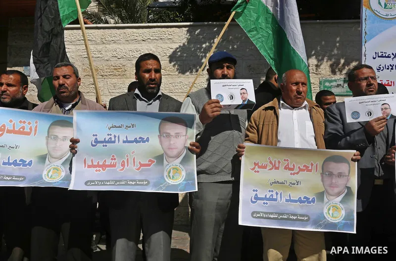 Palestinians hold posters during a demonstration in support of hunger striking Palestinian journalist Mohammed al-Qiq, in front of Red cross office in Gaza city on February 9, 2016. The 33-year-old television reporter wi...