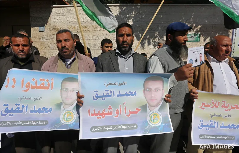 Palestinians hold posters during a demonstration in support of hunger striking Palestinian journalist Mohammed al-Qiq, in front of Red cross office in Gaza city on February 9, 2016. The 33-year-old television reporter wi...