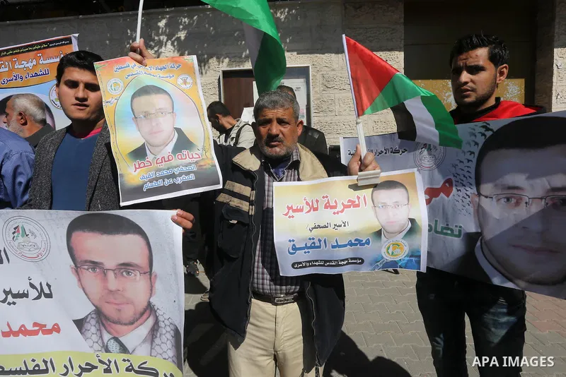 Palestinians hold posters during a demonstration in support of hunger striking Palestinian journalist Mohammed al-Qiq, in front of Red cross office in Gaza city on February 9, 2016. The 33-year-old television reporter wi...