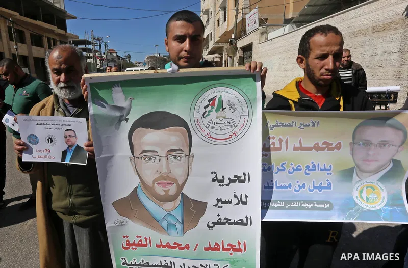 Palestinians hold posters during a demonstration in support of hunger striking Palestinian journalist Mohammed al-Qiq, in front of Red cross office in Gaza city on February 9, 2016. The 33-year-old television reporter wi...