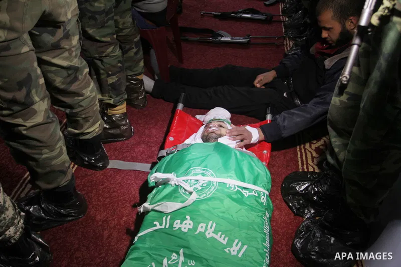 Palestinian members of the Ezzedine al-Qassam Brigades, the armed wing of the Hamas movement pray over the body of their comrade Marwan Maarouf, 27, during his funeral in Khan Yunis in the southern Gaza Strip, on Februar...