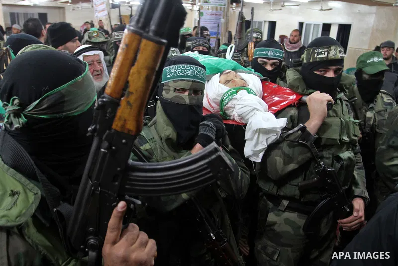 Palestinian members of the Ezzedine al-Qassam Brigades, the armed wing of the Hamas movement carry the body of their comrade Marwan Maarouf, 27, during his funeral in Khan Yunis in the southern Gaza Strip, on February 9,...