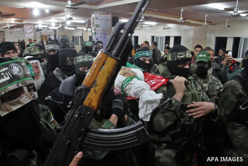 Palestinian members of the Ezzedine al-Qassam Brigades, the armed wing of the Hamas movement carry the body of their comrade Marwan Maarouf, 27, during his funeral in Khan Yunis in the southern Gaza Strip, on February 9,...