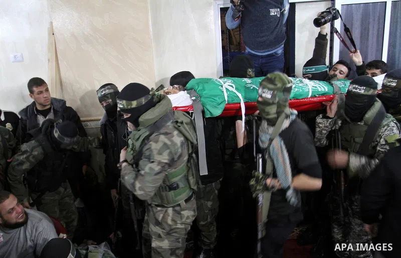 Palestinian members of the Ezzedine al-Qassam Brigades, the armed wing of the Hamas movement carry the body of their comrade Marwan Maarouf, 27, during his funeral in Khan Yunis in the southern Gaza Strip, on February 9,...
