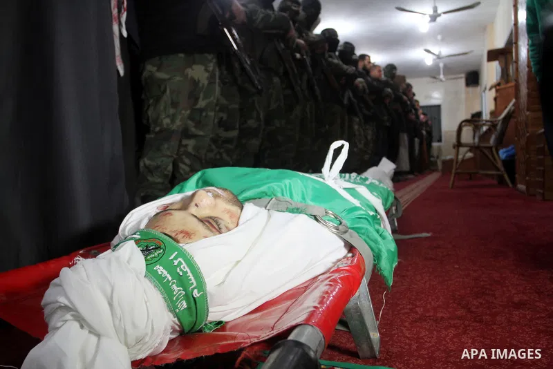 Palestinian members of the Ezzedine al-Qassam Brigades, the armed wing of the Hamas movement pray over the body of their comrade Marwan Maarouf, 27, during his funeral in Khan Yunis in the southern Gaza Strip, on Februar...