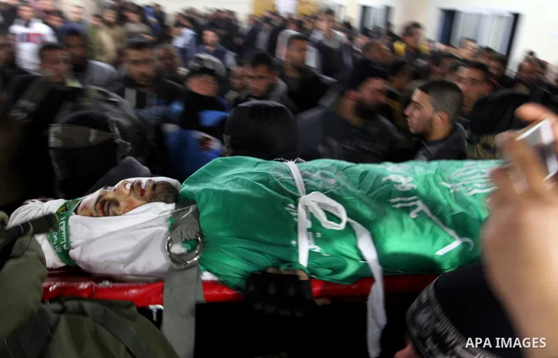 Palestinian members of the Ezzedine al-Qassam Brigades, the armed wing of the Hamas movement carry the body of their comrade Marwan Maarouf, 27, during his funeral in Khan Yunis in the southern Gaza Strip, on February 9,...