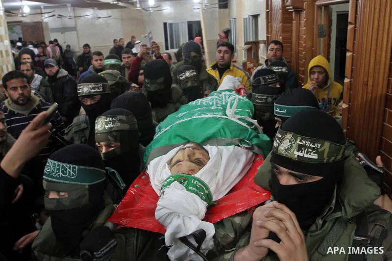 Palestinian members of the Ezzedine al-Qassam Brigades, the armed wing of the Hamas movement carry the body of their comrade Marwan Maarouf, 27, during his funeral in Khan Yunis in the southern Gaza Strip, on February 9,...
