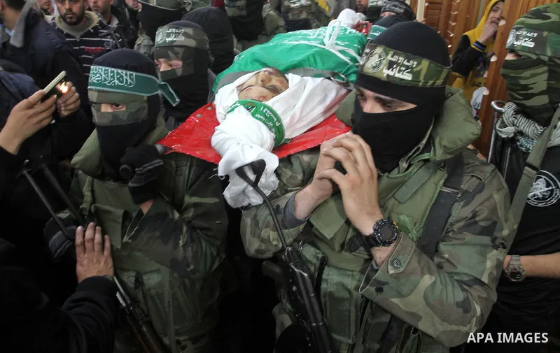 Palestinian members of the Ezzedine al-Qassam Brigades, the armed wing of the Hamas movement carry the body of their comrade Marwan Maarouf, 27, during his funeral in Khan Yunis in the southern Gaza Strip, on February 9,...
