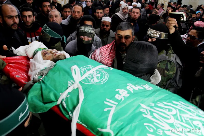 Palestinian members of the Ezzedine al-Qassam Brigades, the armed wing of the Hamas movement carry the body of their comrade Marwan Maarouf, 27, during his funeral in Khan Yunis in the southern Gaza Strip, on February 9,...