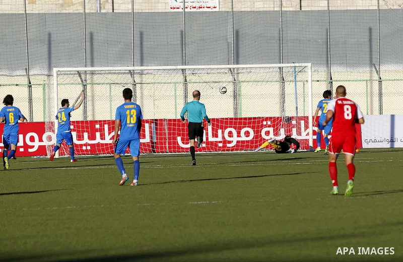 Ahly Al-Khalil football club's players (in red) and FC Khujand club's players compete during the football match crucial AFC Champions League Playoff phase at Dura Stadium in the West Bank city of Hebron on Feb. 09, 2016....