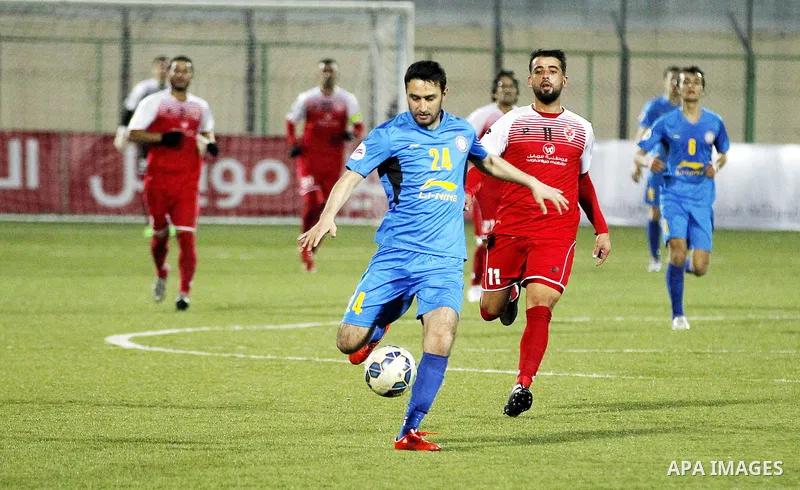 Ahly Al-Khalil football club's players (in red) and FC Khujand club's players compete during the football match crucial AFC Champions League Playoff phase at Dura Stadium in the West Bank city of Hebron on Feb. 09, 2016....