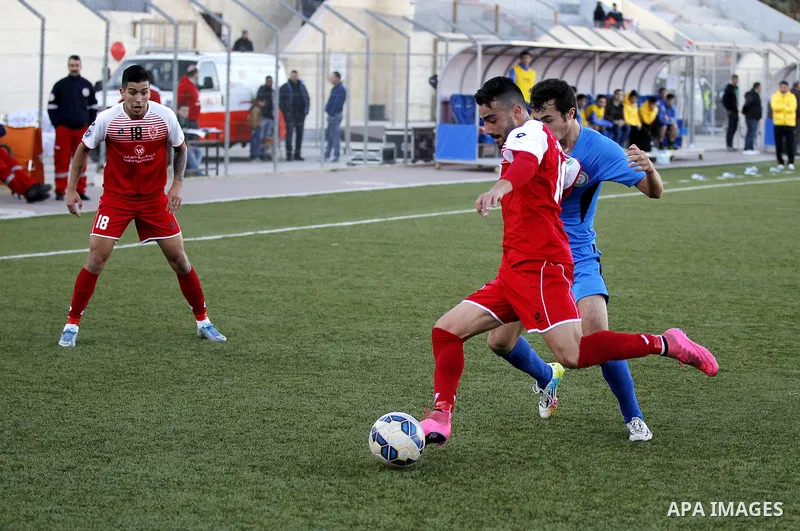 Ahly Al-Khalil football club's players (in red) and FC Khujand club's players compete during the football match crucial AFC Champions League Playoff phase at Dura Stadium in the West Bank city of Hebron on Feb. 09, 2016....