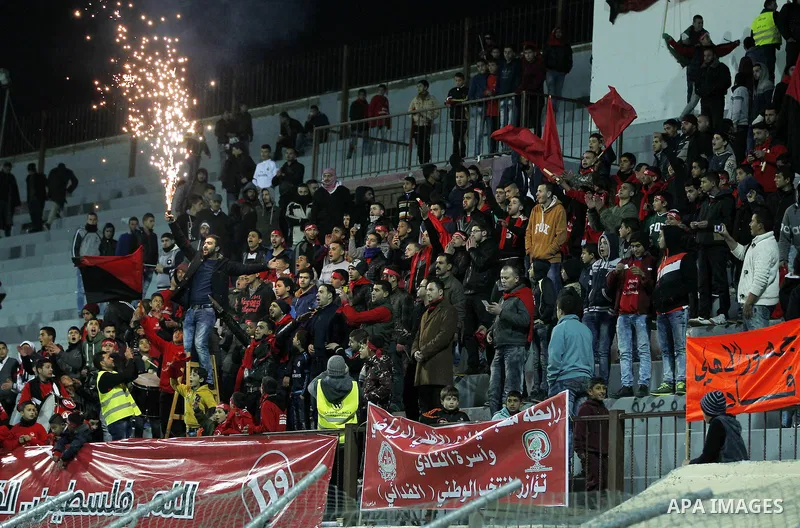 Fans attend the crucial AFC Champions League Playoff phase football match between Palestinian's Ahly Al-Khalil football team and FC Khujand team at Dura Stadium in the West Bank city of Hebron on Feb. 09, 2016. Mahmoud W...