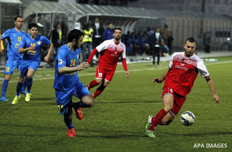 Ahly Al-Khalil football club's players (in red) and FC Khujand club's players compete during the football match crucial AFC Champions League Playoff phase at Dura Stadium in the West Bank city of Hebron on Feb. 09, 2016....