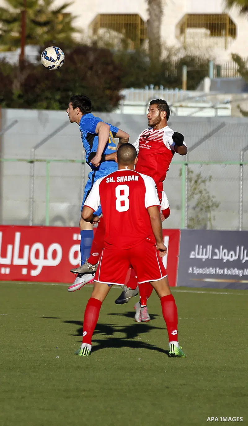 Ahly Al-Khalil football club's players (in red) and FC Khujand club's players compete during the football match crucial AFC Champions League Playoff phase at Dura Stadium in the West Bank city of Hebron on Feb. 09, 2016....