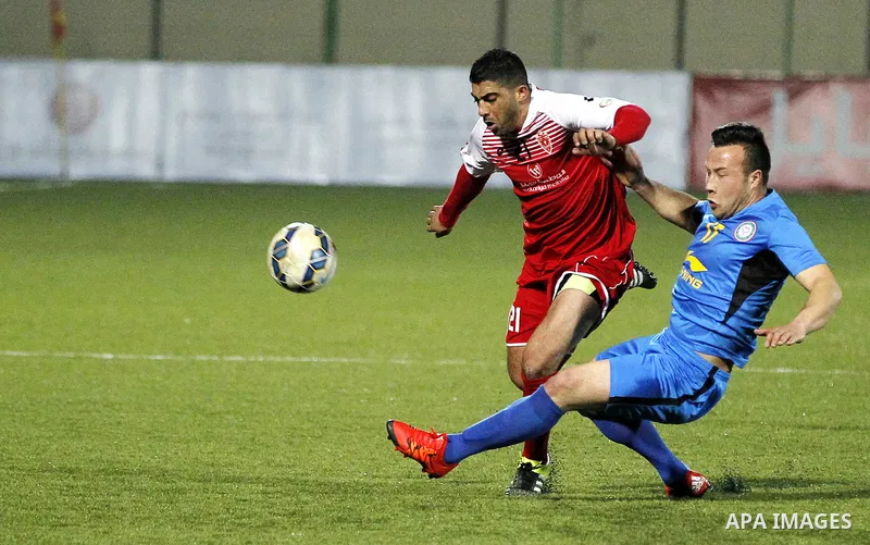 Ahly Al-Khalil football club's players (in red) and FC Khujand club's players compete during the football match crucial AFC Champions League Playoff phase at Dura Stadium in the West Bank city of Hebron on Feb. 09, 2016....