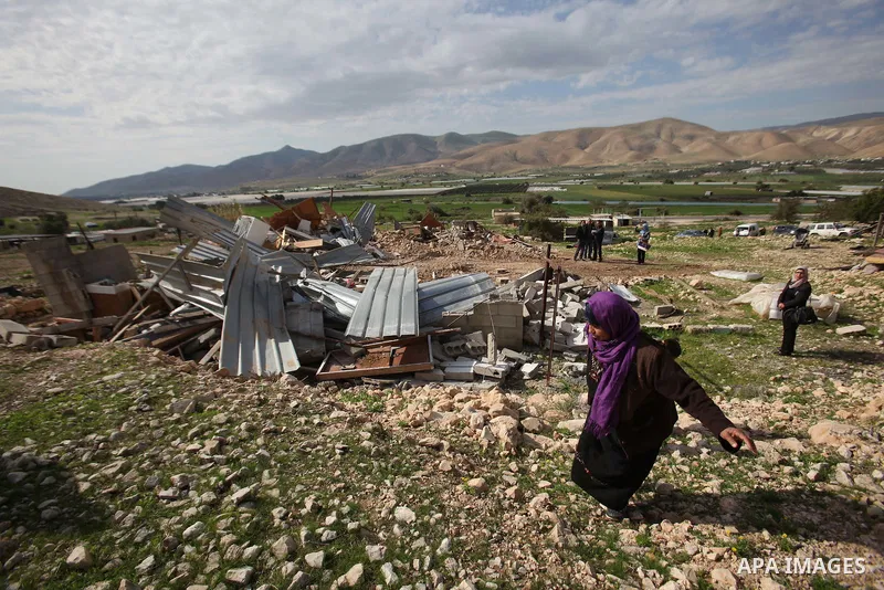 Palestinians collect belongings near the rubble of their house that were demolished by the Israeli army, in the village of El-Jiftlik north the west bank city of jericho, on February 10, 2016. The owners of the house sai...