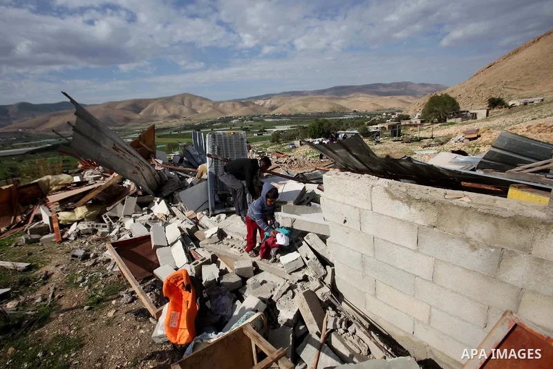 Palestinians collect belongings near the rubble of their house that were demolished by the Israeli army, in the village of El-Jiftlik north the west bank city of jericho, on February 10, 2016. The owners of the house sai...