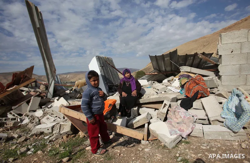 Palestinians collect belongings near the rubble of their house that were demolished by the Israeli army, in the village of El-Jiftlik north the west bank city of jericho, on February 10, 2016. The owners of the house sai...