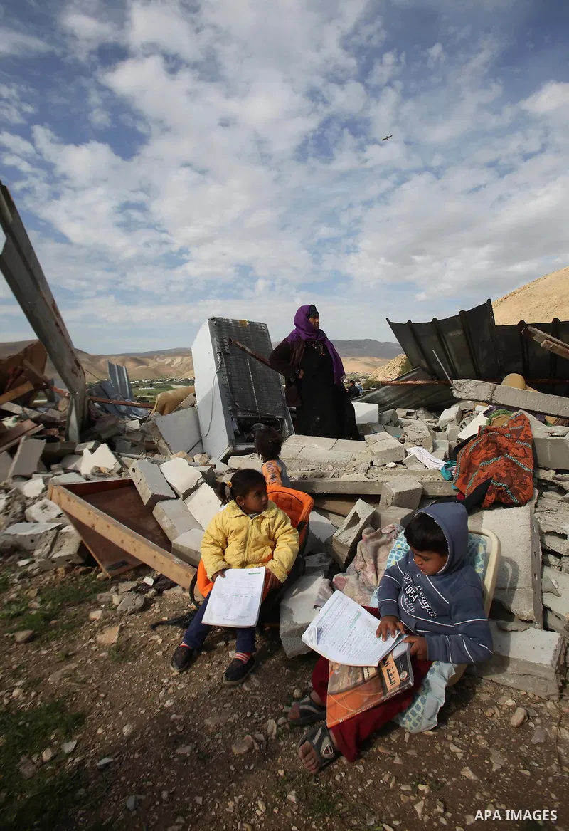 Palestinians collect belongings near the rubble of their house that were demolished by the Israeli army, in the village of El-Jiftlik north the west bank city of jericho, on February 10, 2016. The owners of the house sai...