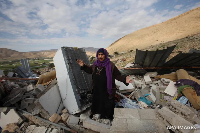 Palestinians collect belongings near the rubble of their house that were demolished by the Israeli army, in the village of El-Jiftlik north the west bank city of jericho, on February 10, 2016. The owners of the house sai...