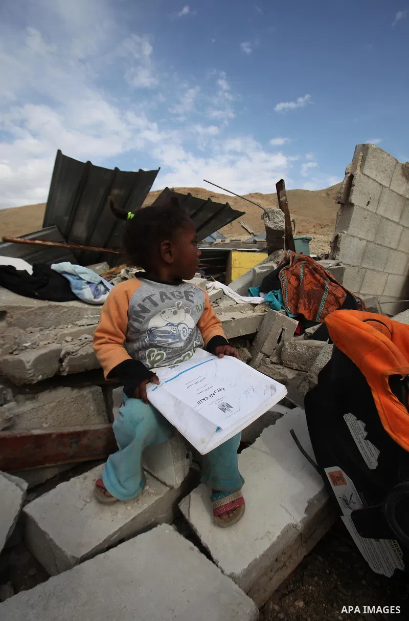 Palestinians collect belongings near the rubble of their house that were demolished by the Israeli army, in the village of El-Jiftlik north the west bank city of jericho, on February 10, 2016. The owners of the house sai...