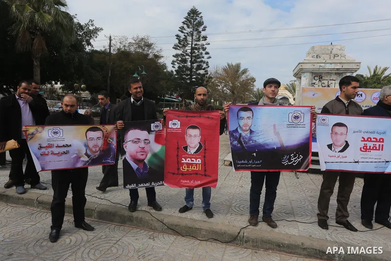 Palestinians hold posters during a protest in support of hunger striking Palestinian journalist Mohammed al-Qiq, in in Gaza city on February 10, 2016. The 33-year-old television reporter will keep up his 10-week hunger s...