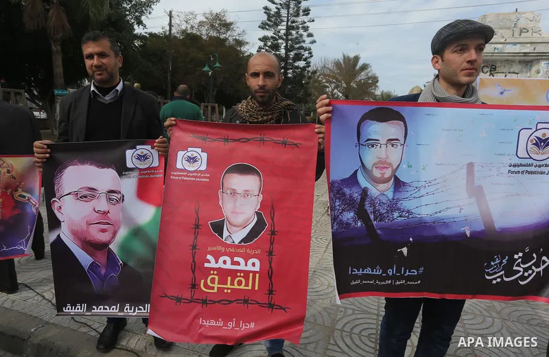 Palestinians hold posters during a protest in support of hunger striking Palestinian journalist Mohammed al-Qiq, in in Gaza city on February 10, 2016. The 33-year-old television reporter will keep up his 10-week hunger s...