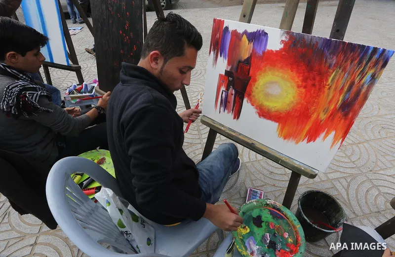 Palestinian artists paint artwork during a protest in support of hunger striking Palestinian journalist Mohammed al-Qiq, in in Gaza city on February 10, 2016. The 33-year-old television reporter will keep up his 10-week...