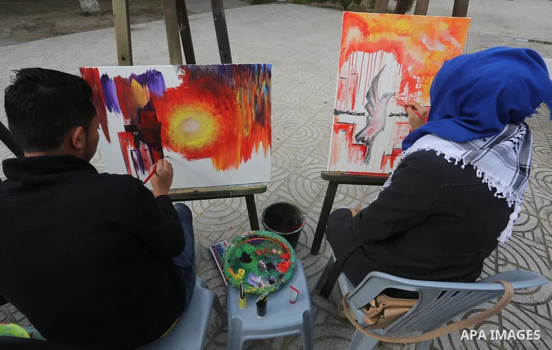 Palestinian artists paint artwork during a protest in support of hunger striking Palestinian journalist Mohammed al-Qiq, in in Gaza city on February 10, 2016. The 33-year-old television reporter will keep up his 10-week...