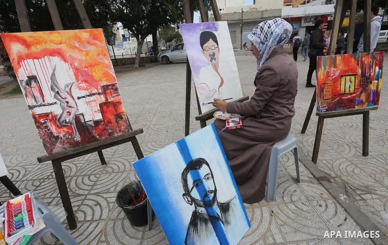 Palestinian artists paint artwork during a protest in support of hunger striking Palestinian journalist Mohammed al-Qiq, in in Gaza city on February 10, 2016. The 33-year-old television reporter will keep up his 10-week...