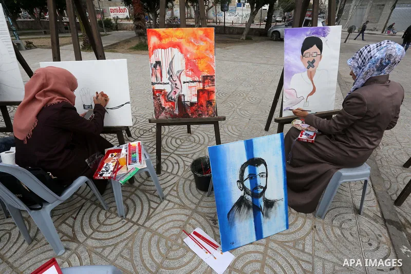Palestinian artists paint artwork during a protest in support of hunger striking Palestinian journalist Mohammed al-Qiq, in in Gaza city on February 10, 2016. The 33-year-old television reporter will keep up his 10-week...