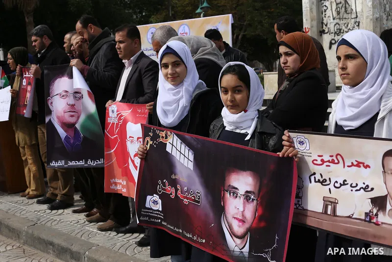 Palestinians hold posters during a protest in support of hunger striking Palestinian journalist Mohammed al-Qiq, in in Gaza city on February 10, 2016. The 33-year-old television reporter will keep up his 10-week hunger s...