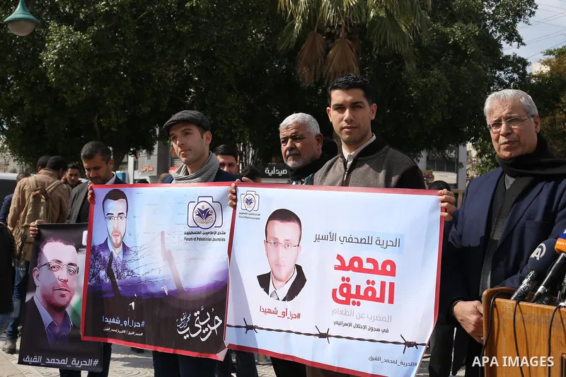 Palestinians hold posters during a protest in support of hunger striking Palestinian journalist Mohammed al-Qiq, in in Gaza city on February 10, 2016. The 33-year-old television reporter will keep up his 10-week hunger s...