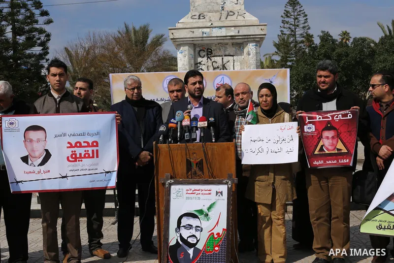 Palestinians hold posters during a protest in support of hunger striking Palestinian journalist Mohammed al-Qiq, in in Gaza city on February 10, 2016. The 33-year-old television reporter will keep up his 10-week hunger s...