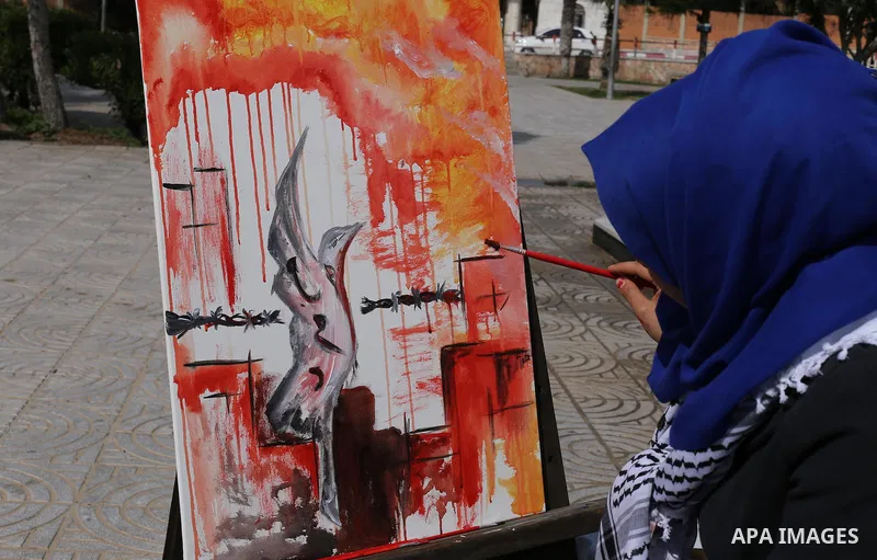 Palestinian artists paint artwork during a protest in support of hunger striking Palestinian journalist Mohammed al-Qiq, in in Gaza city on February 10, 2016. The 33-year-old television reporter will keep up his 10-week...