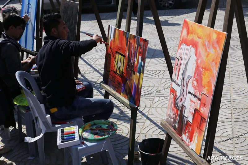 Palestinian artists paint artwork during a protest in support of hunger striking Palestinian journalist Mohammed al-Qiq, in in Gaza city on February 10, 2016. The 33-year-old television reporter will keep up his 10-week...
