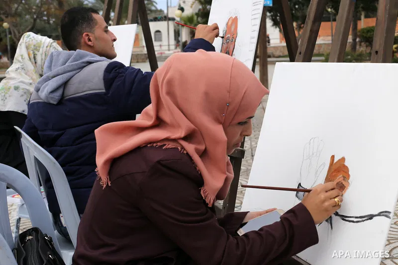 Palestinian artists paint artwork during a protest in support of hunger striking Palestinian journalist Mohammed al-Qiq, in in Gaza city on February 10, 2016. The 33-year-old television reporter will keep up his 10-week...
