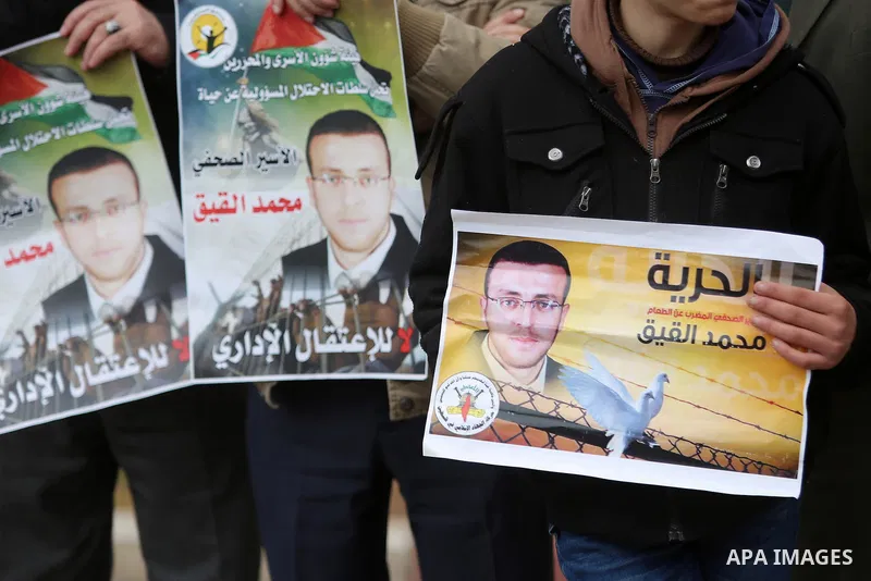 Palestinians hold posters during a protest in support of hunger striking Palestinian journalist Mohammed al-Qiq, in the West Bank city of Ramallah on February 11, 2016. The 33-year-old television reporter will keep up hi...