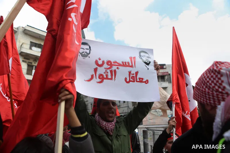 Palestinians hold posters during a protest in support of hunger striking Palestinian journalist Mohammed al-Qiq, in the West Bank city of Ramallah on February 11, 2016. The 33-year-old television reporter will keep up hi...