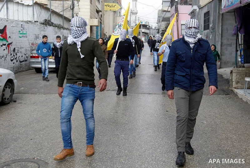 Masked Palestinians take part in the funeral of Omar Jawabra, who was killed by Israeli fire during clashes near hebron the day before, at al-Aroub Palestinian refugee camp, north the West Bank city of Hebron on February...